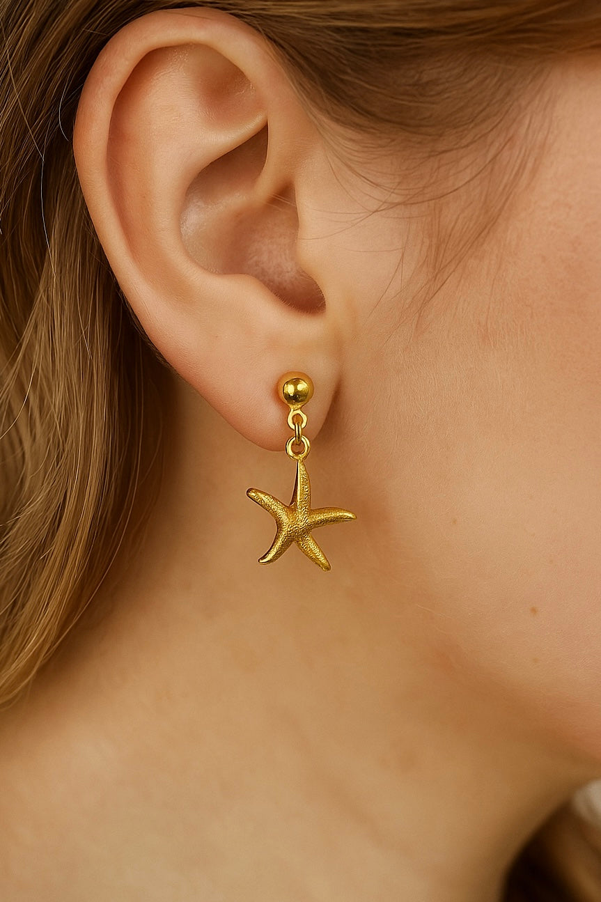 Golden sea stars gold stainless steel earrings on a model