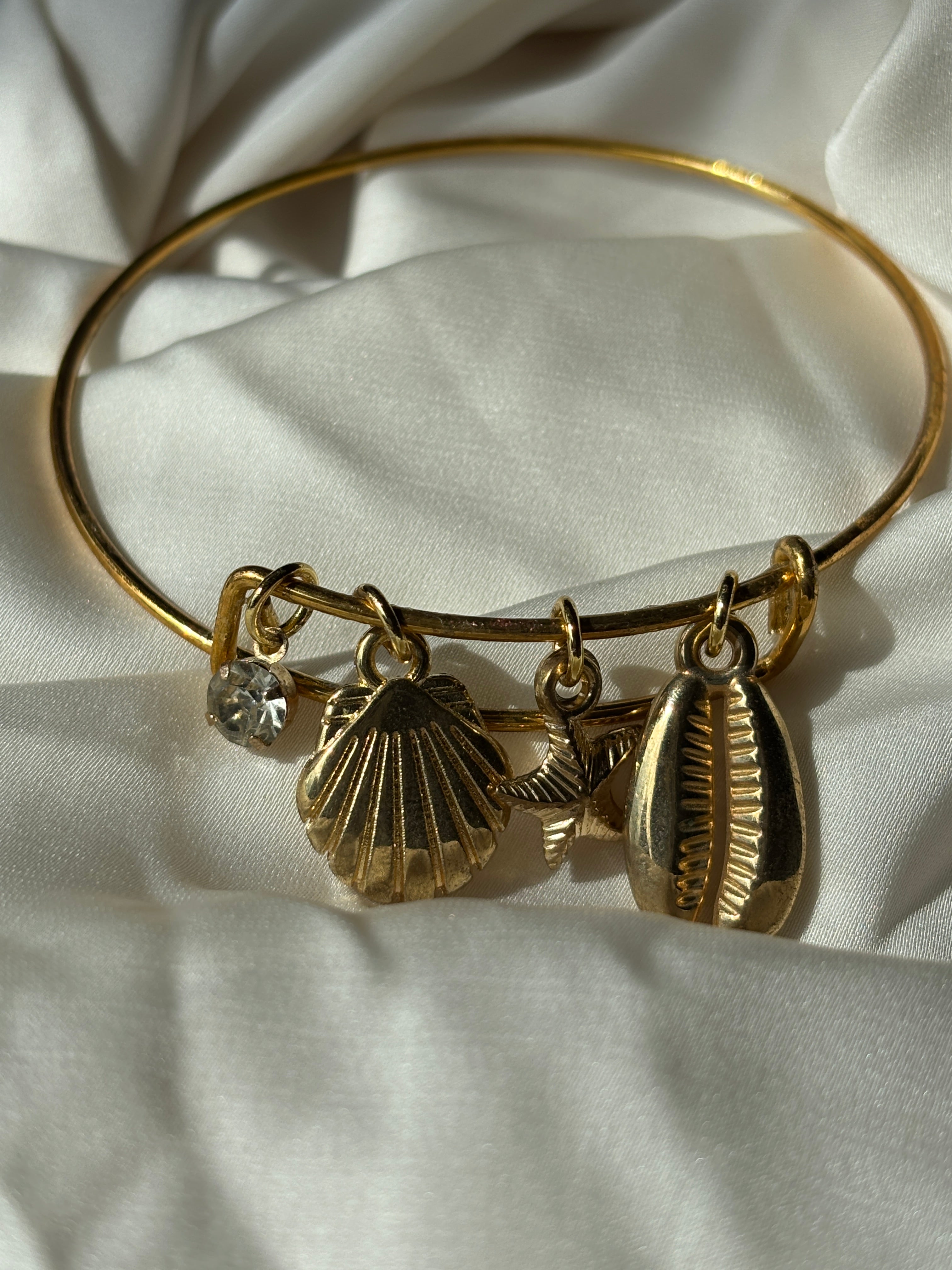 salted gold bracelet on a white fabric surface