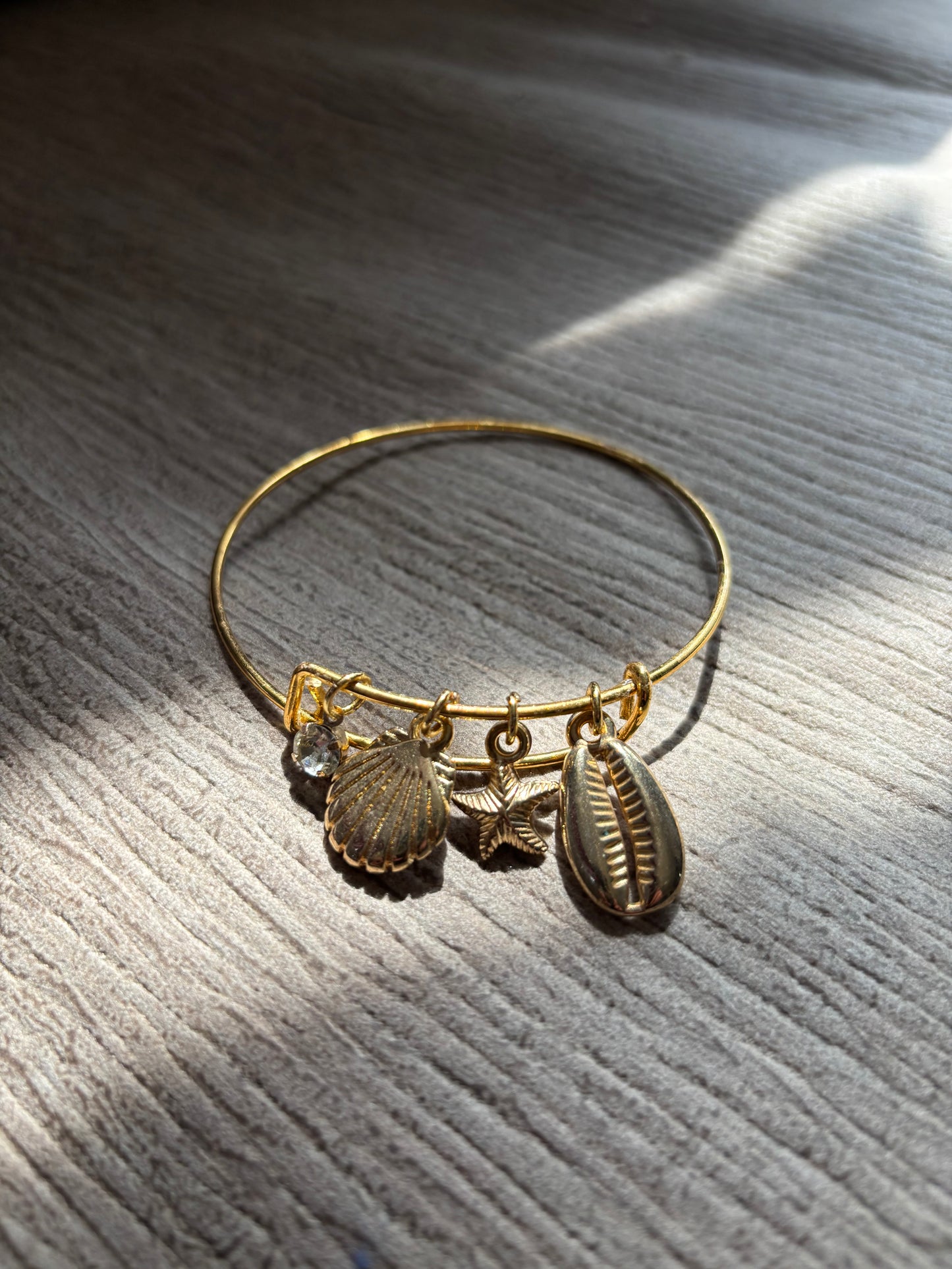 Salted gold Summer bracelet ajustable with shells on a beige backround with nice lighting