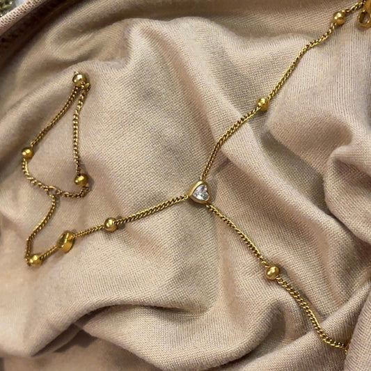 Amara Heart Hand Chain 18K Gold on beige backround