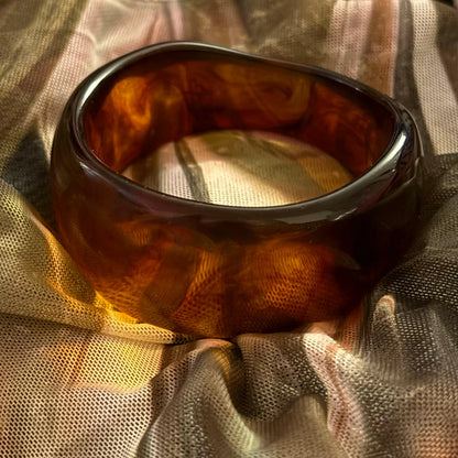 Ember Aura Resin Bangle on a geometric backround